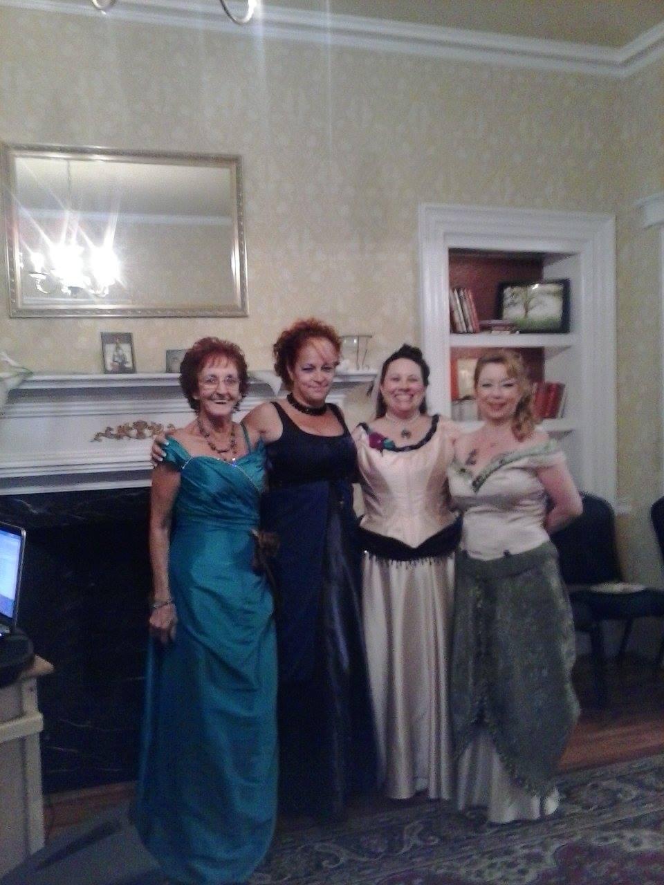 A picture of me and 3 other women all wearing gowns that I created.
From left to right
Turquoise Gown with rhinstone trim and brown satin bow that is removable. Also has a brown removeable bustle with turquoise rhinestone center.
Deep Blue Gown is an Edwardian Style Gown with an Empire waitsline and chiffon cascading down the front splitting to reveal a shimmering satin skirt. Chiffon cascade is trimmed in dangling beads.
Silk Cream Bridal gown, I restyled this gown for my vow renewal. Cascades of Teal, plum and blue satins were added for a train as well as danging beads, all from recycled skirts and draperies. A repurposed plum velvet drapery swag was used to create the front, Victorian-style drape in the front of the gown.
Sage and Cream two-piece, dress was also created by restyling a modern 2-piece special occasion outfit with repurposed draperies, trims and fabric to create a Victorian-era style evening gown.