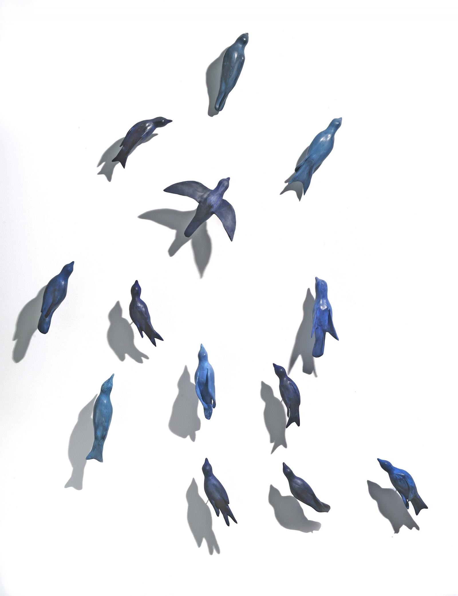 responding to the impact of climate crises on bird migrations, this is a small group (13) of blue birds migrating in formation; comprised of clay and pigments.