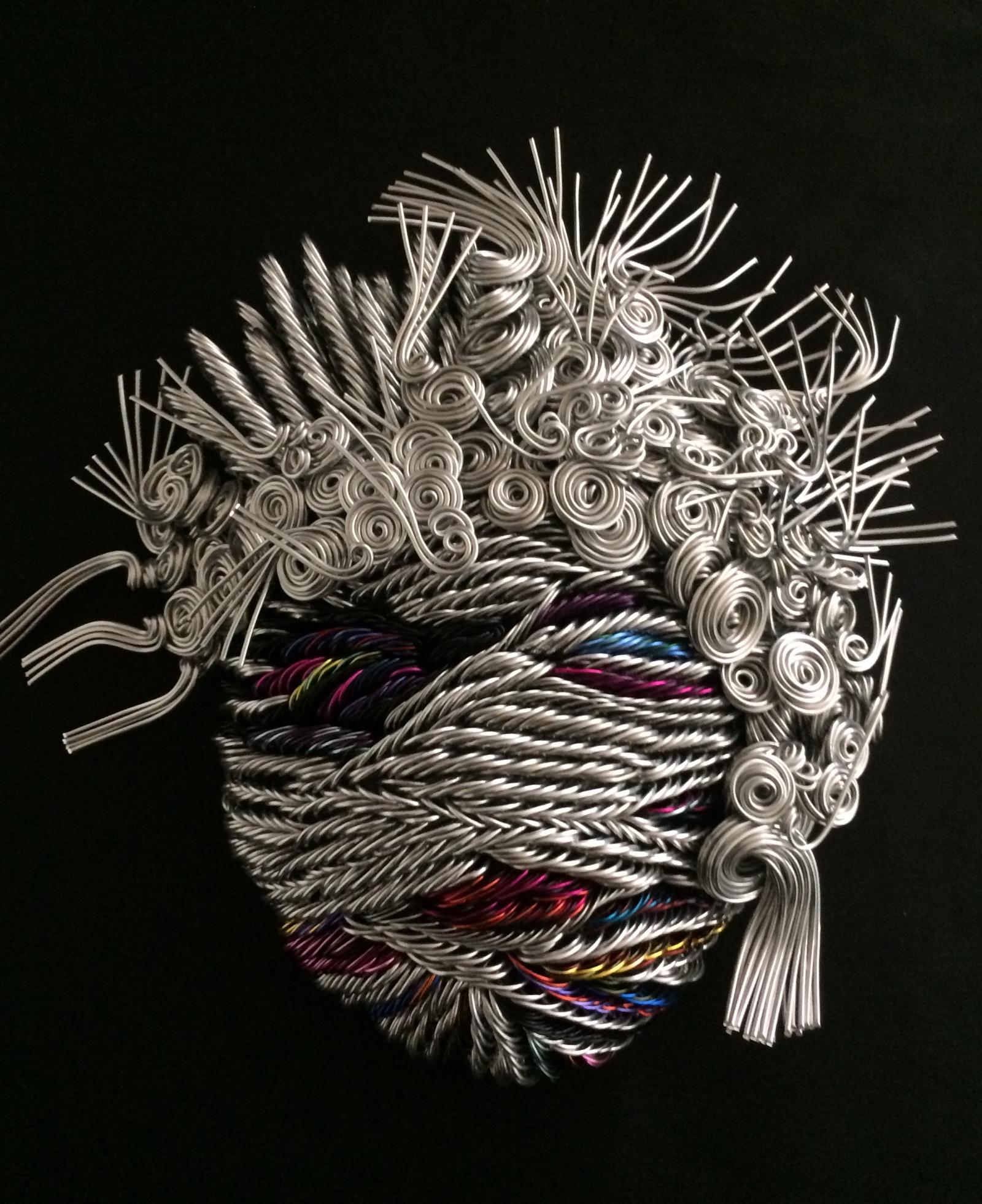 From 500-700 colored wire strands of various lengths and gauges are shaped and twisted into mask sculpture.