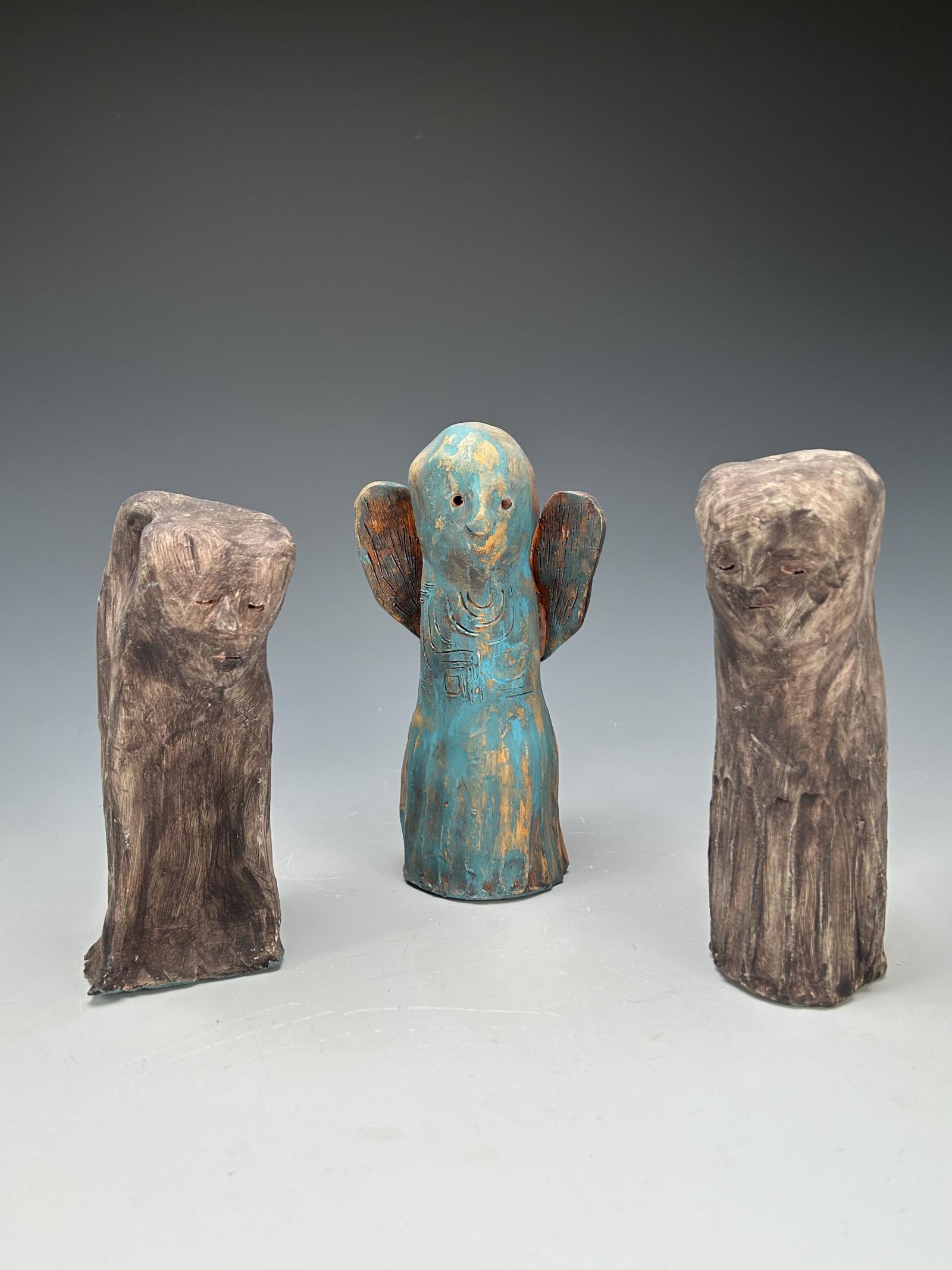 Three small sculptures, two human figures and one angel.