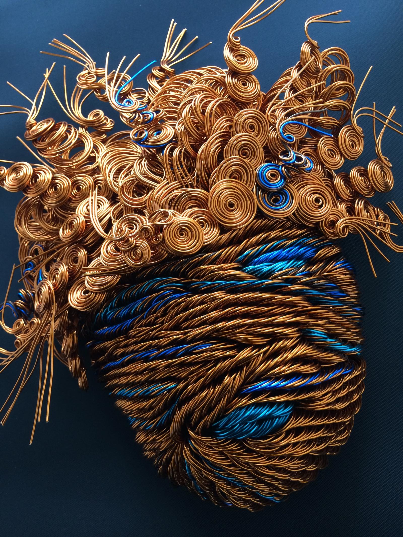 From 500-700 colored wire strands of various lengths and gauges are shapes and twisted into mask sculpture.
