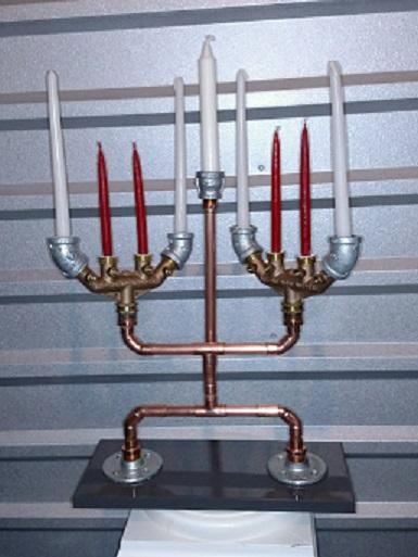 This Menorah is made from repurposed copper pipe and plumbing fittings and rests on a wooden base.