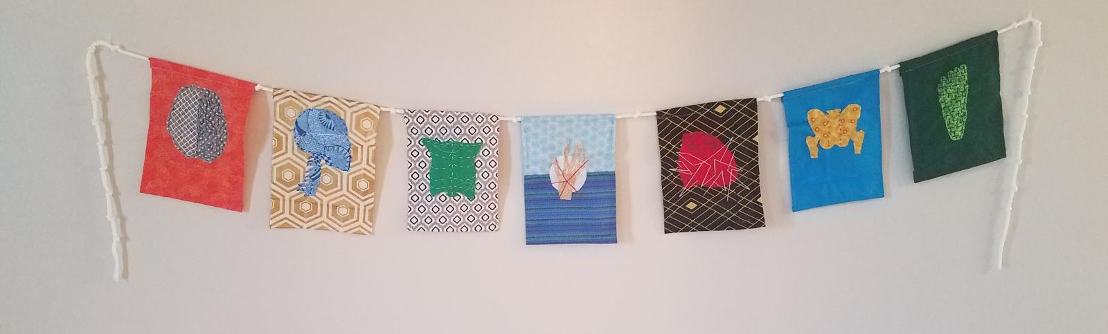 stitched fabric flags with rope on wood background
