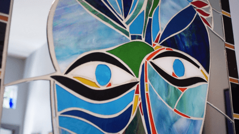 Close up of a blue, black, and green mosaic face