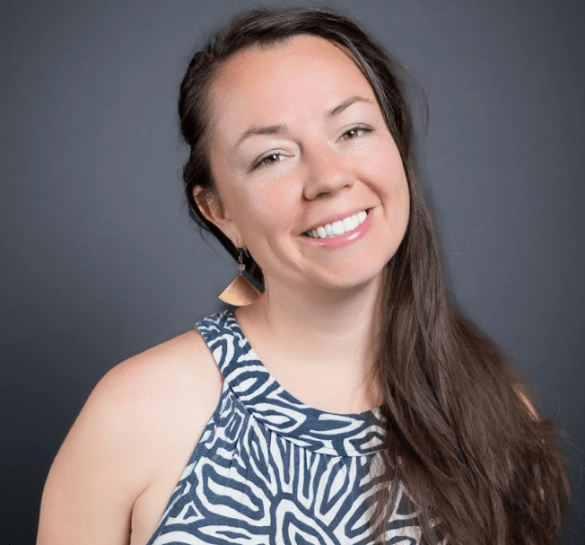 Smiling woman with long, brown hair and patterned black and white top