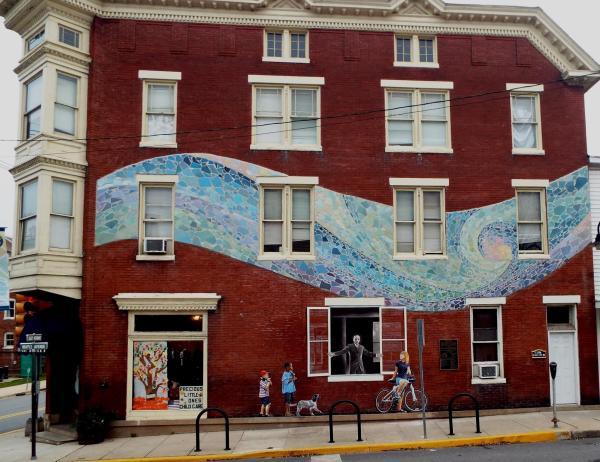 The mural was made out of thousands of hammer-cracked floor tiles meant to show the Potomac River as a flowing and swirling image of energy. Standing in a wide-open window was an image of Dr. Arlington Horine himself. In the mural, he is depicted in black and white with his arms wide open.