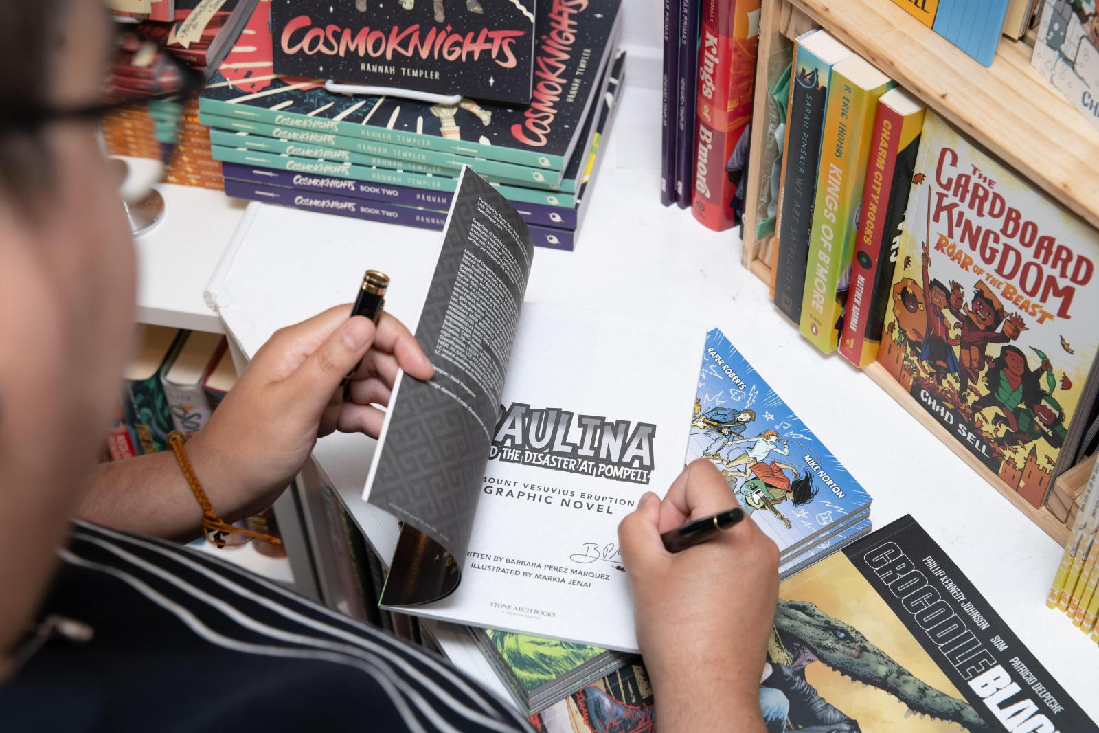 Writer Barbara Perez Marquez signing a graphic novel (Baltimore City).