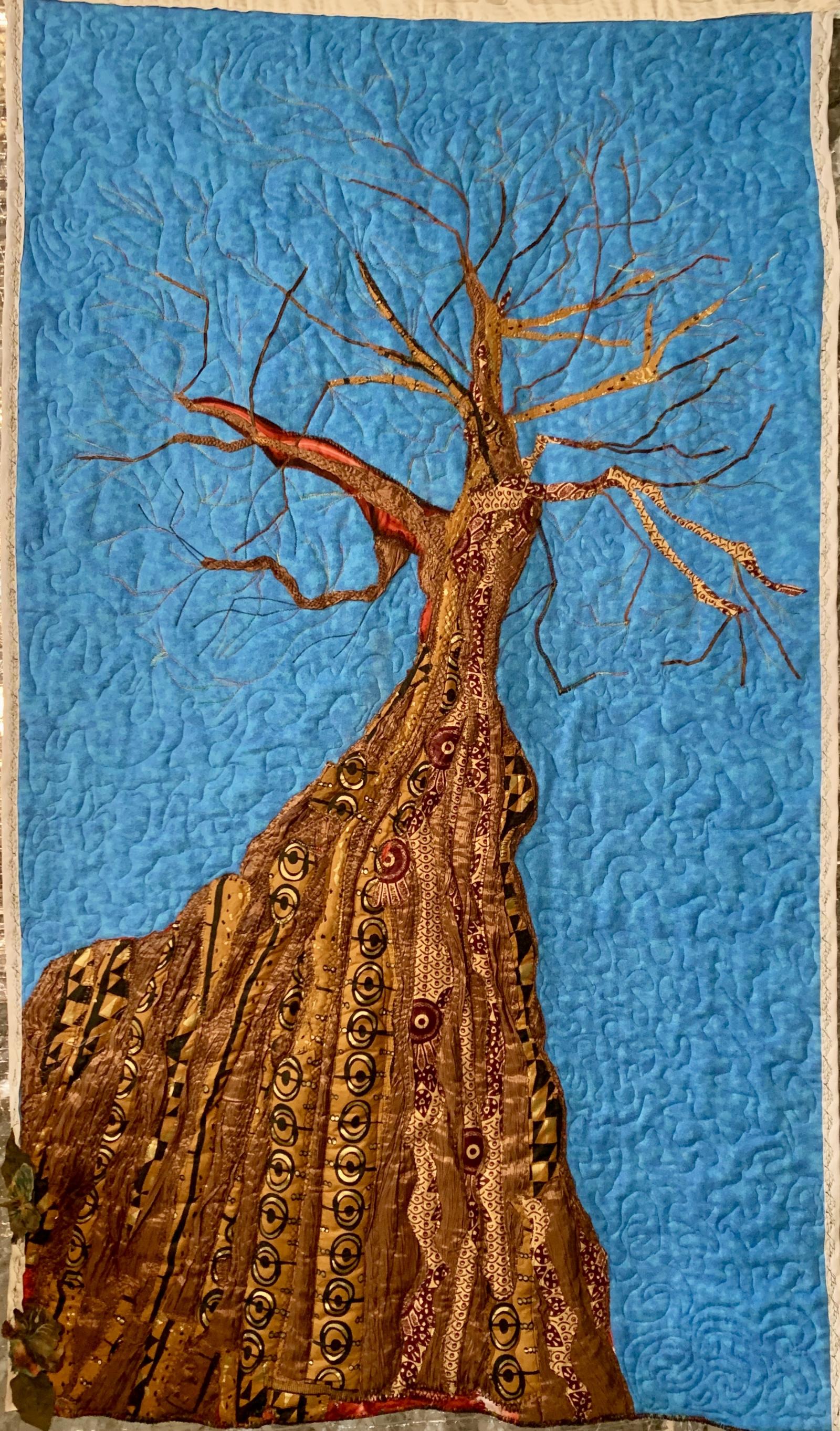 African Wax print cottons with recycled poly fabric applique on flannel. Couching ribbon, metallic treads, embroidery. Free motion quilting. Image depicts the intertwined nature of the African American family tree with both African and western influences. At the same time, it shows the "blood on the leaf and blood on the root" connoting the lynches of Black bodies that are as much of our history and current manifestations as our African roots.