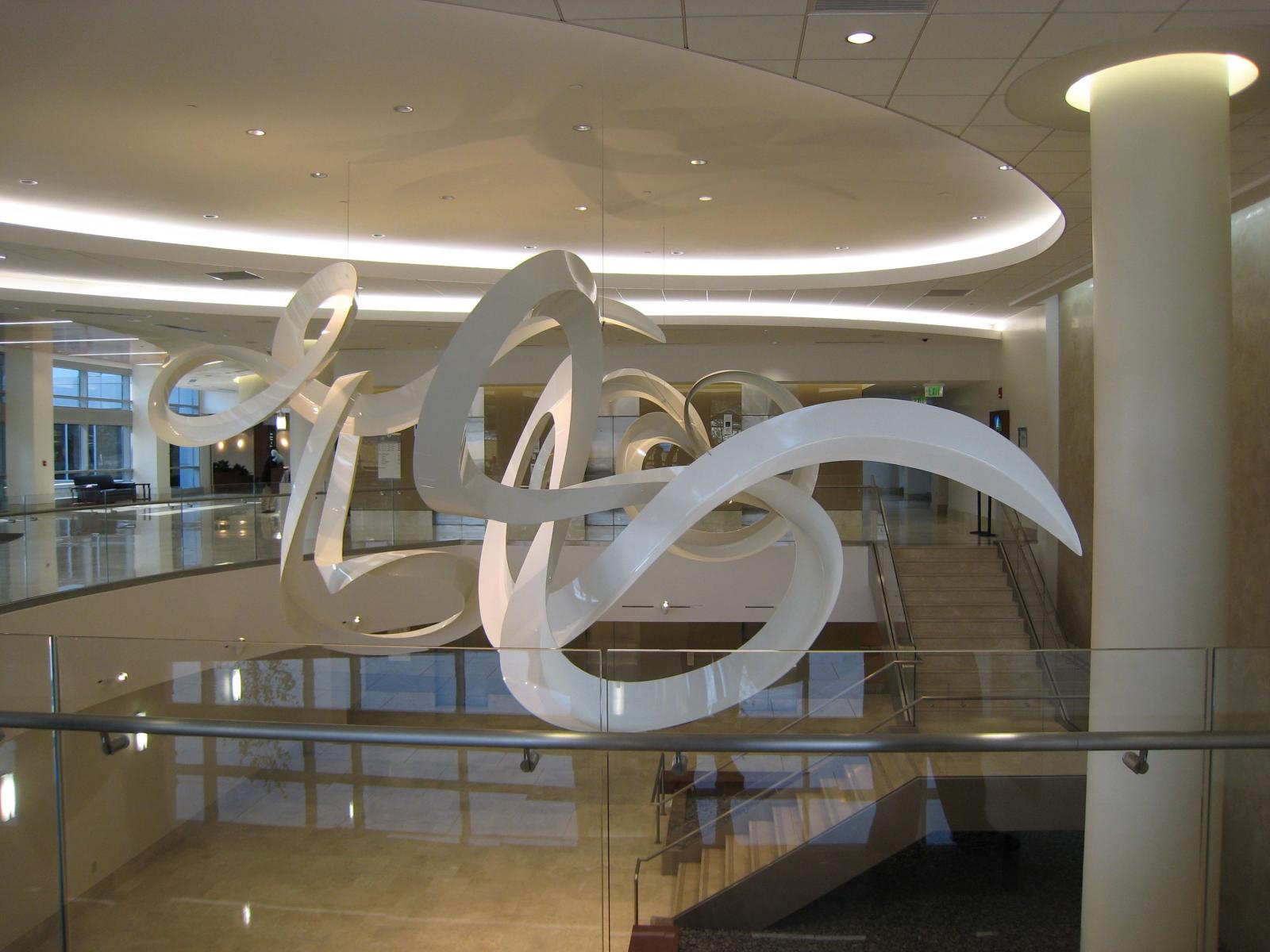 Spun Grace is designed in response to the architecture of the new building and the very special spirit and mission of St. Agnes Hospital. It is intended to be graceful; the gentle calligraphic curves convey a sense of fluid movement, intriguing the viewer as the pieces slowly move and create new configurations. It is hoped that the evolving interaction of the forms will be engaging while evoking a sense of serenity for people who are waiting in the atrium area.