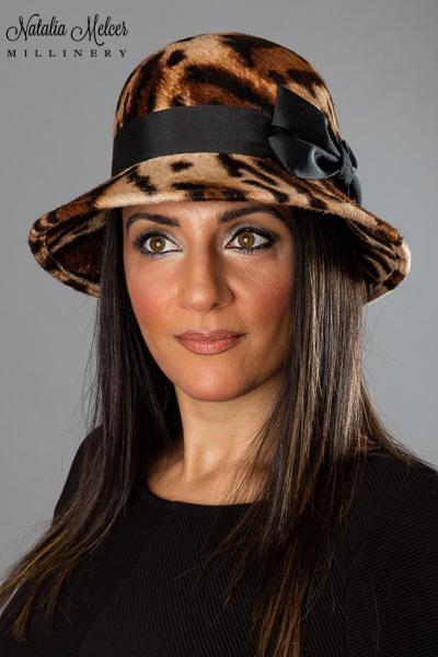 Jaguar print fur felt hat with black ribbon and bow trim. A sweatband is sewn inside the crown. Hat was made by blocking the felt over a wooden form. One-of-a-kind, handmade hat using traditional millinery techniques.