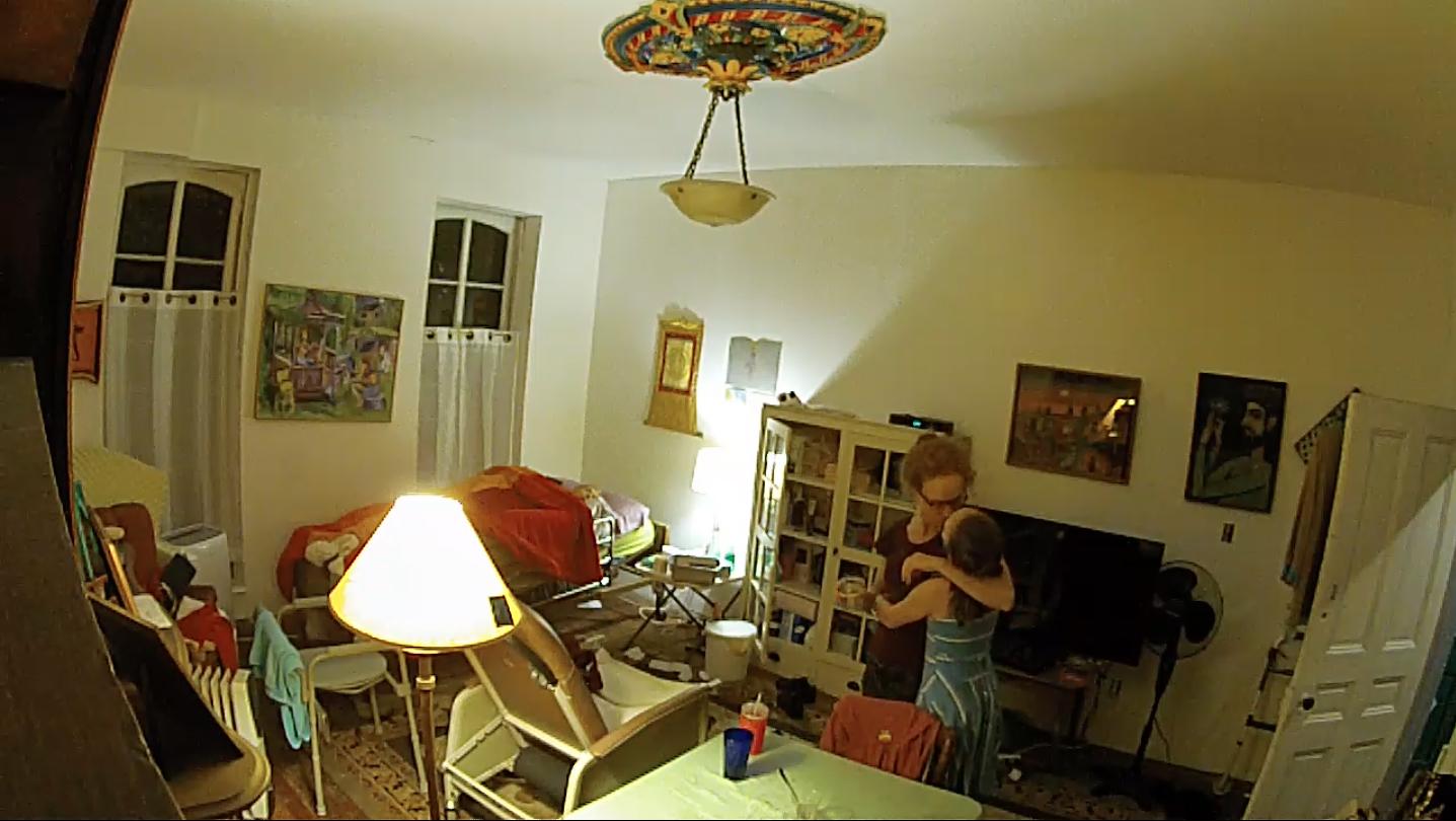 When my mother was left for dead at her assisted living facility, I committed to caring for her 24/7 and treated the experience as a living art project. A surveillance camera I installed before leaving for a five-week video job remained on after my return. The videos, culled from 300 days of footage, form a quotidian ballet as furniture position, clothing, light, and our movement changes. As I watched her steady return to the womb—legs crossed, hands clenched, knees bent, hips and trunk flexed—I was at once witnessing her death, and participating in my own. Noelle is a collection of prints and an interactive video and sound installation that uses real time compositing and chroma keying to place the viewer in the video—both the object of the camera and voyeur.  