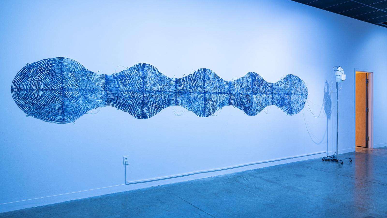 Wavelengths is an active wall installation where water is pumped through tubing at 1 second intervals and interwoven through a large scale cyanotype paper collage. The laser cut pattern resembles ripples in water, sound waves, veins, and even fingerprint ridges in an attempt to create a melding or intersection of body and landscape. Just as our bodies consist mostly of water, so does the Earth.