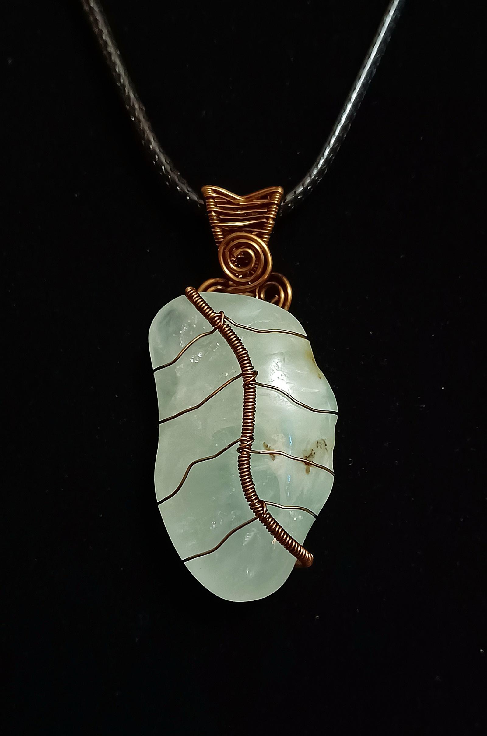 Aquamarine wrapped in brass colored copper wire