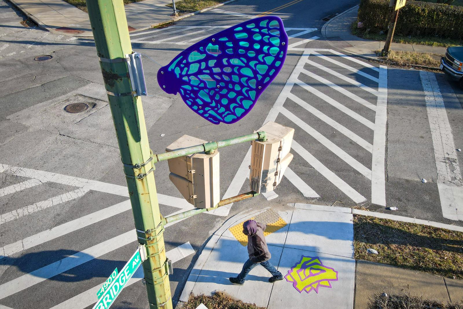 Pimlico Wayfinding
https://grahamprojects.com/projects/pimlico-wayfinding/ 
Acrylic, polycarbonate, 3M Dichroic finish, thermoplastic, traffic paint
Dimension vary
January 2021
Oakley Avenue corridor, Baltimore, MD 21215
The Pimlico Wayfinding art path connects Pimlico Elementary Middle School students and residents of the surrounding Park Heights neighborhood with CC Jackson Recreation Center to the west and Cylburn Arboretum to the east via colorful sidewalk butterfly stencils, thermoplastic flower markers, and prismatic butterfly street signs. The artwork was created in collaboration with community artist Whitney Frazier and is based on input from neighborhood residents and inspired by local flora and pollinators.
Project partners: Pimlico Elementary Middle School, Cylburn Arboretum, Park Heights Renaissance, Cylburn Community Association, Baltimore City Department of Recreation and Parks