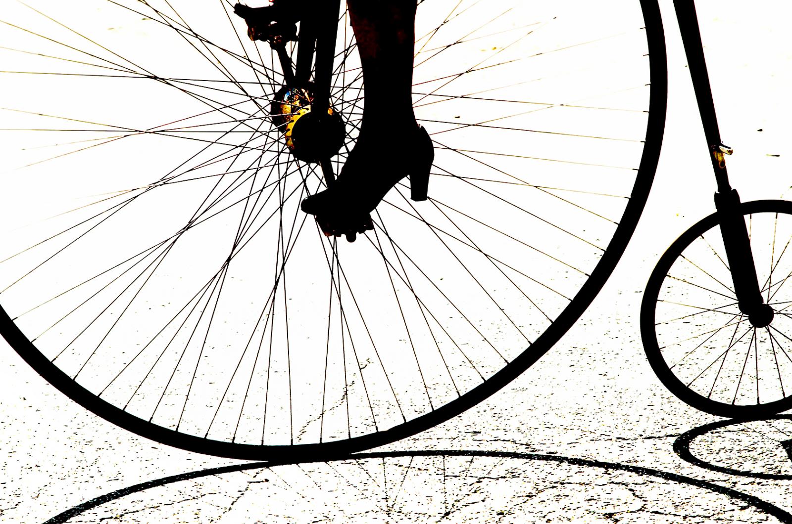 Silhouette of woman riding a penny farthing