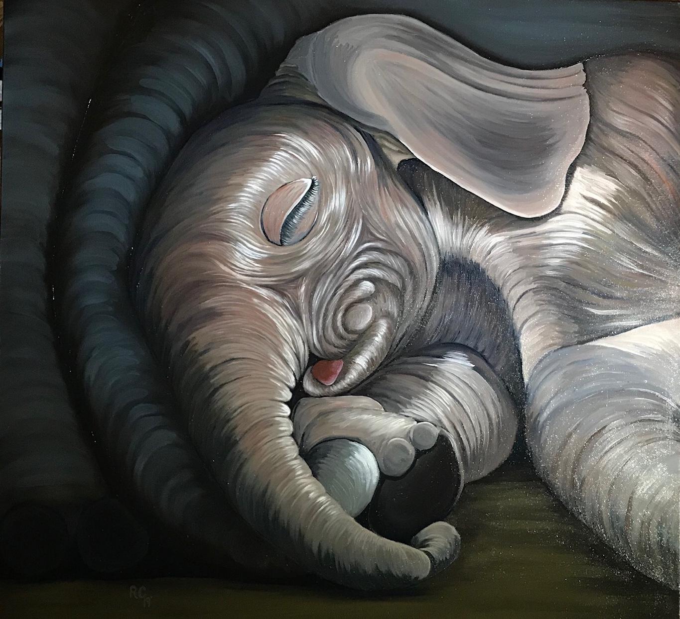 A beautiful image of a sleeping baby elephant snuggled into its Mommas trunk.
