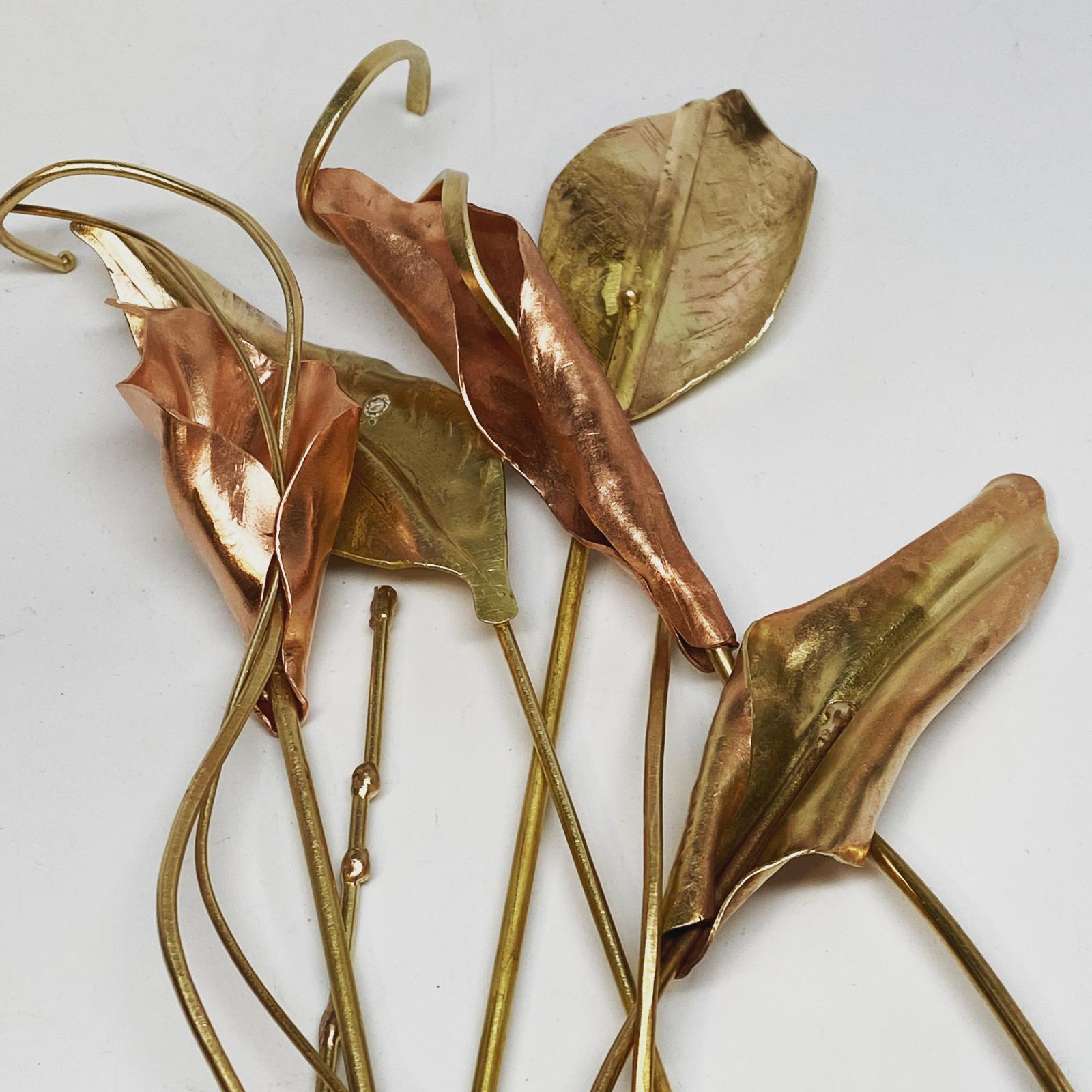 This is a piece of sculpture in progress. I bought silk flowers and leaves and used them as patterns to make these forms in brass, bronze, and copper. Some or all of these will be welded together at the bronze "stems". For the final bouquet, argentium silver items will be added. This is done last because silver cannot with-stand the same level of torch heat as the other metals used. The final sculpture will either be placed in an actual vase or in the top of a finished wood block with 1-2 holes drilled.
