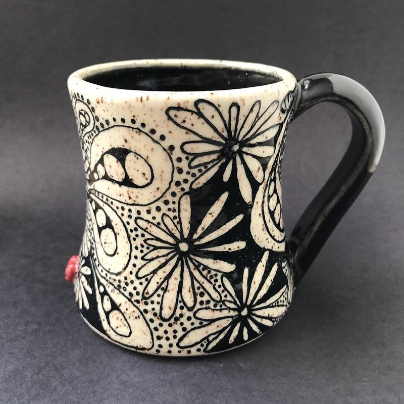 Get your zen on! This spectacular black & white beauty is a zentangle of doodles accented with a tiny red heart and holds 10 - 12 ounces of coffee, tea, or whatever you choose. (This piece has been sold.)
All my mugs are hand-thrown by yours truly and are unique in their size, shape, and design... no two are ever exactly alike. I'm a small batch potter, designing and creating roughly 20 pieces at a time. Countless hours go into the creation of these mini-artworks... it is a true labor of love.