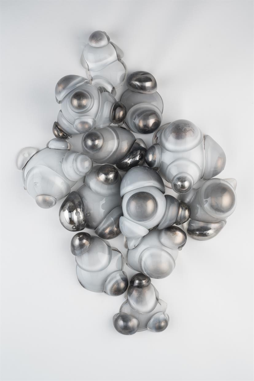 White colored glass was blown, cut and then mirrored. Pieces were then fused together to form a composition on the wall.