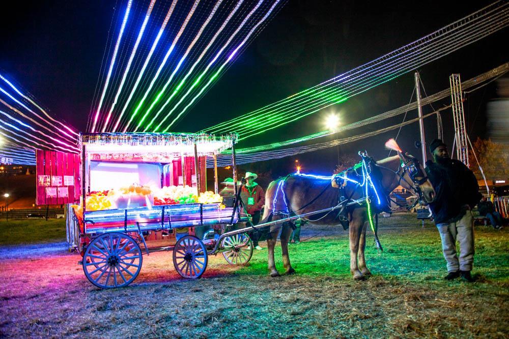 Baltimore Fancy tells the story of the Arabbers, Baltimore’s traditional street vendors. It consists of two elements—a lit and decorated Arabber horse and cart, and a stable, where a magical canopy will provide a sense of place and history. Each night, the stable and cart first present an ethereal light show. Like a vacant store-front or an empty neighborhood, they are mere ghosts. Then, as Arabber and horse arrive and harness up to the cart, the light show comes colorfully alive, reminding us that it is only through use and human interaction that traditions are sustainable and our neighborhoods remain alive.
We built this piece with the arabbers in the Fremont Street Stable during the fall of 2019. We got to know the farm hands, the animals, and the equipment. A full, down to the bare metal, restoration was conducted on an old cart that had rotted away. New oak and ash wood was used and then covered in Formstone Castle's signature LED and chrome look. 1000s of LED lit fruit in boxes were lovingly arranged by our arabbers each night. A skill passed down father to son for generations. Part sculpture, part performance, the piece started each night with the arrival of a real horse which we suited up in her traditional Baltimore Fancy harness and attached to the cart. Music would start as the horse and cart would head out into the crowded footprint of Light City to hand out light up fruit to the crowd.