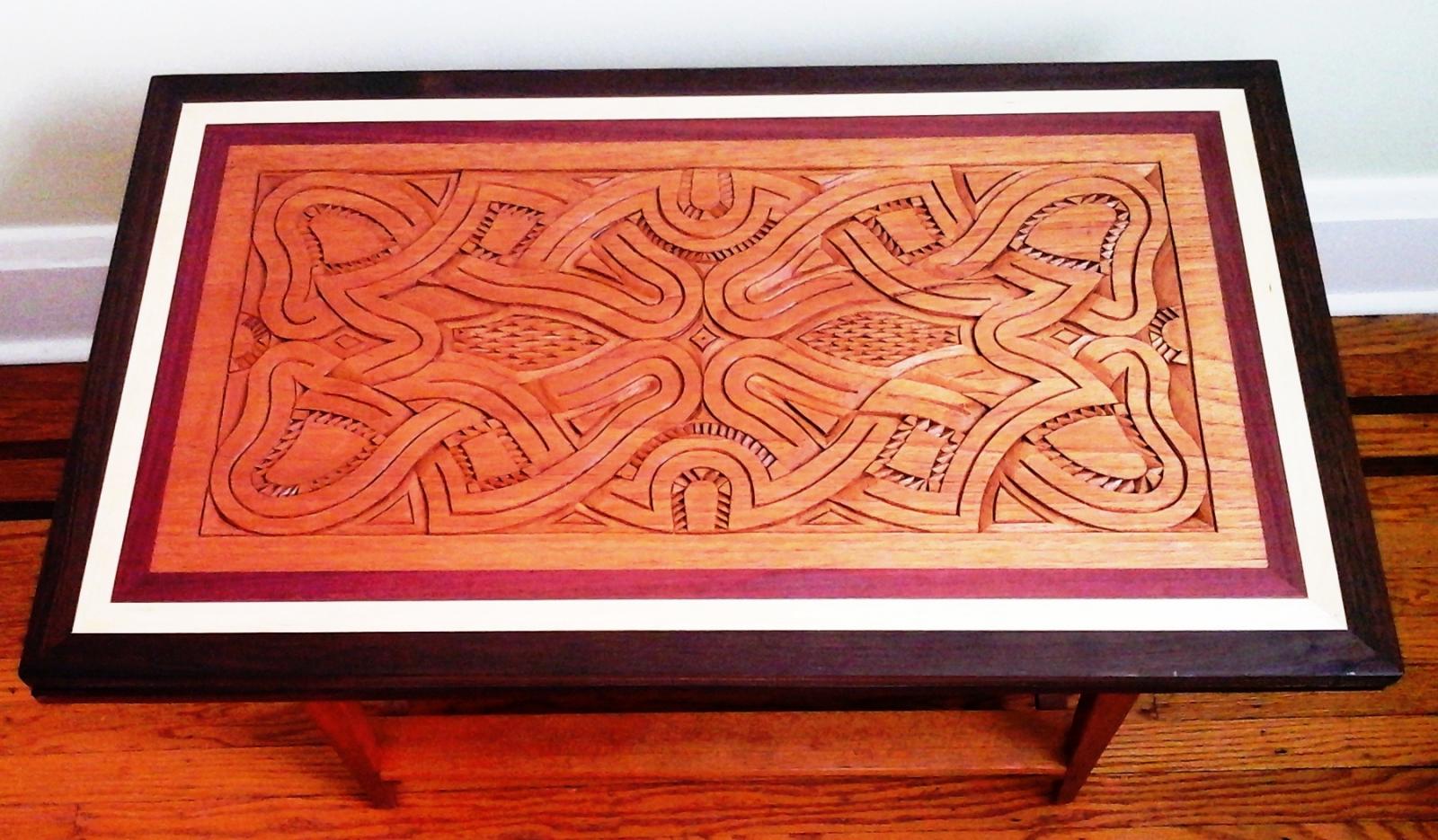 “Heart Loops” Traditional Carved Tabletop/Wall Hanging/Door Panel
L 34 ¾ “ W 20 ½” w/table stand H 19 ¾” Carving: tropical cedar Frame: Peruvian Walnut, Maple, Purple Heart Table Base: Cedar