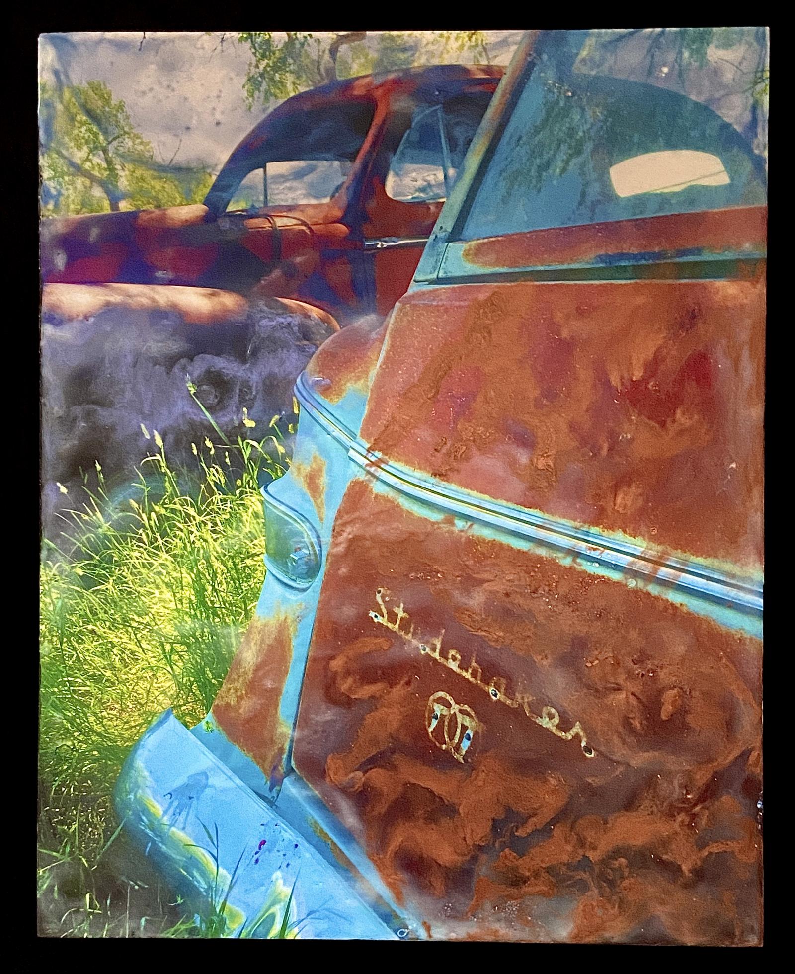 This photo was taken in a ghost town called Ardmore, SD. Abandoned buildings and cars are surrounded by deep grass and an eerie silence in this forgotten place. I transformed the image with layers of melted beeswax, resin, and other materials to create dreamlike effects.