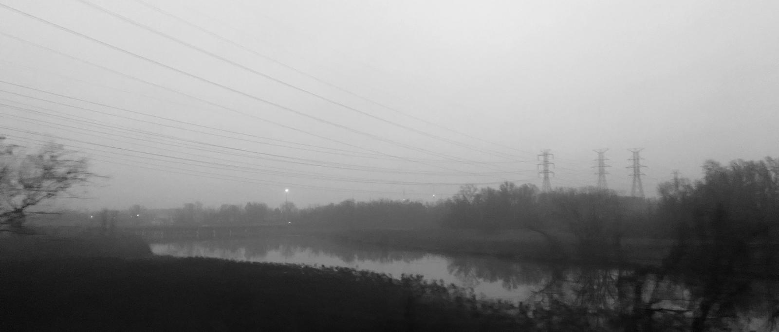 Black and White photograph of an area of Back River from the Marc Train in motion. Photograph made with an iPhone.