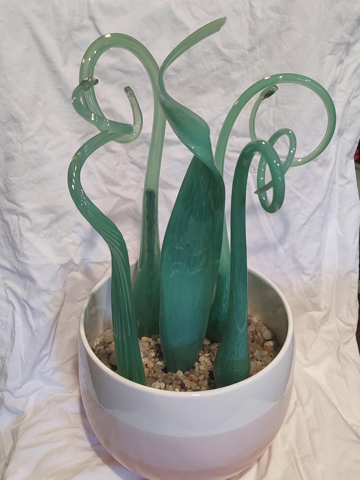 A collection of 5 jade colored 'leaves' in a pale pink and white bowl