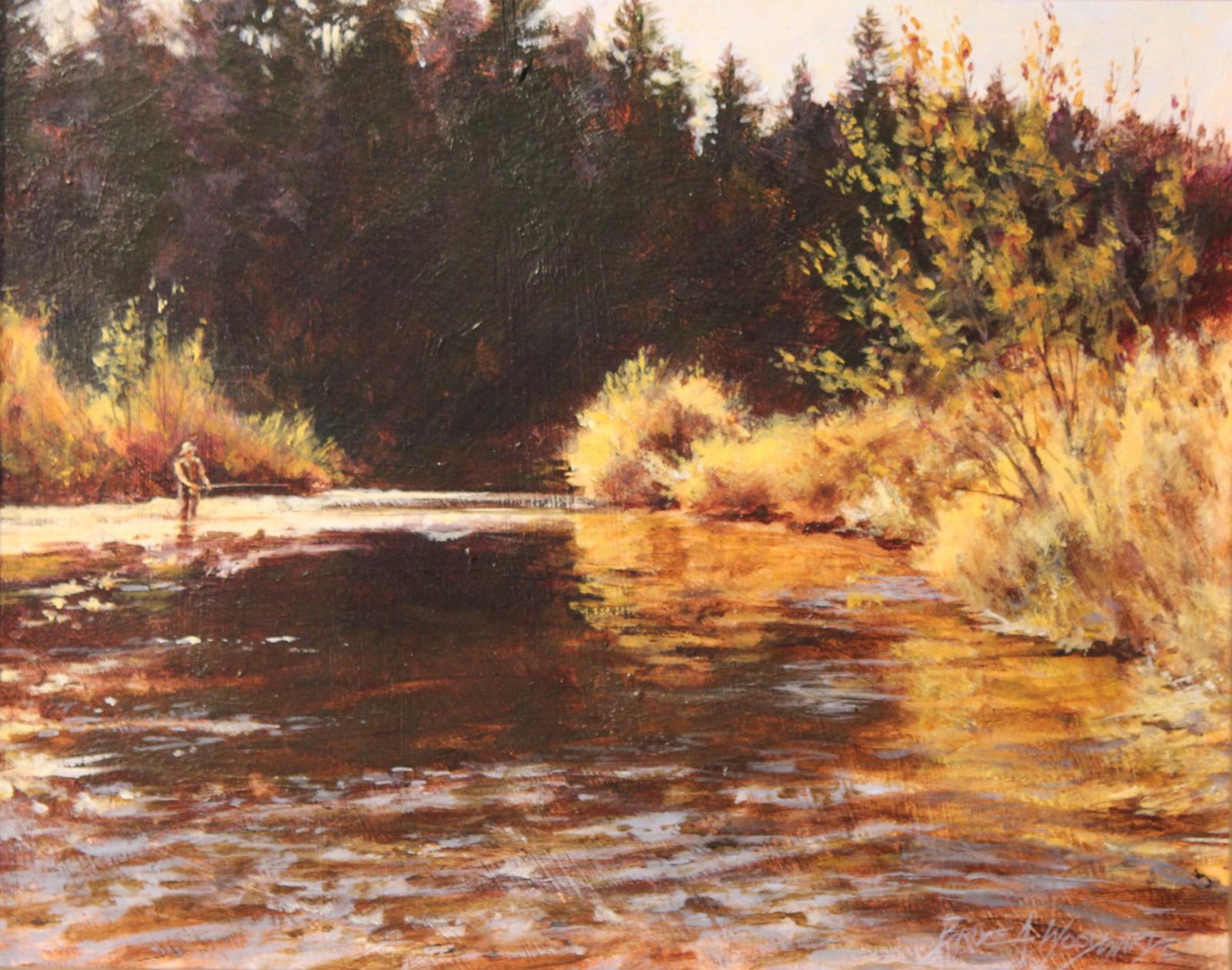 Late afternoon sun in October illuminates a fly fisherman on Big Spring Creek in Montana.