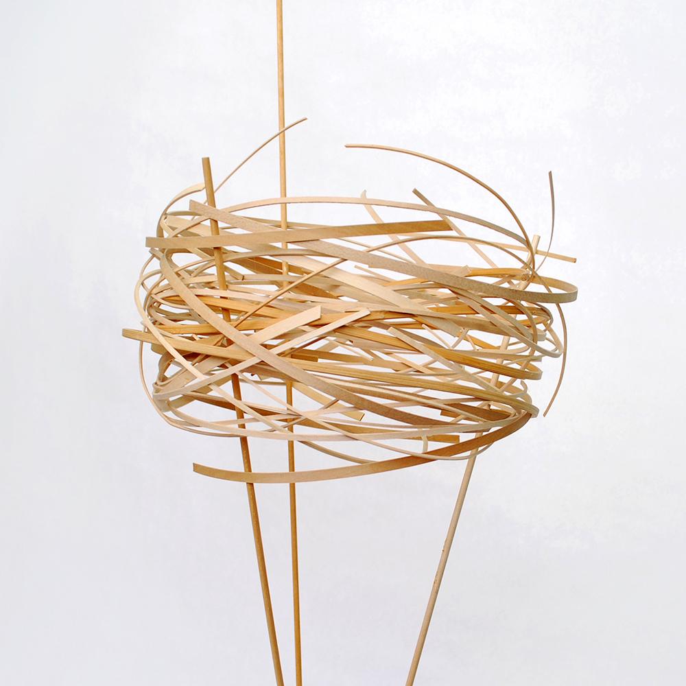 Encircling is about the nature of shaping space through simple wrapping. There's a type of embracing that occurs as the verticals twist around one another and help guide three slender wood threads.