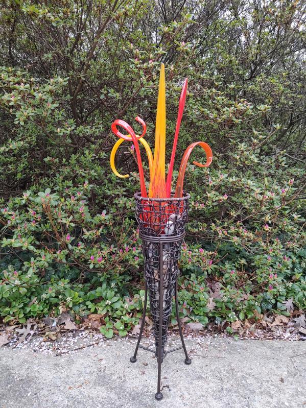 Bright orange/red/yellow glass 'flames' sit inside a wrought iron and wicker base.  