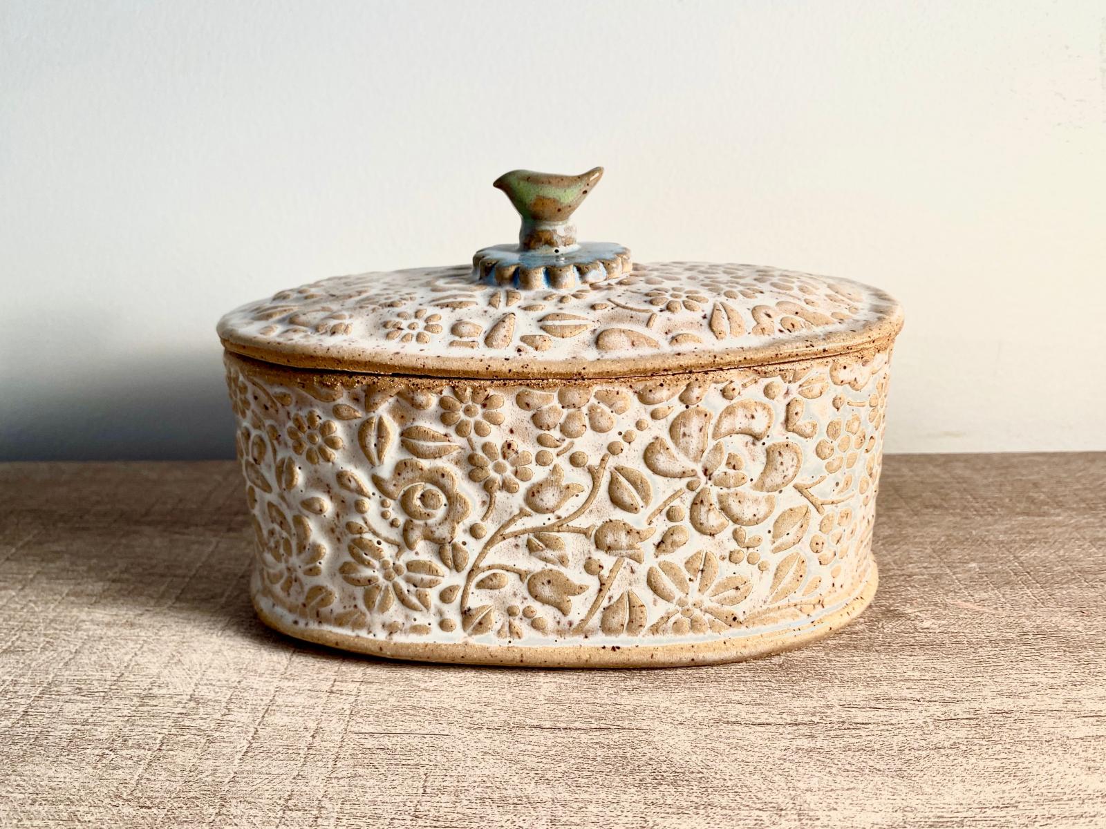 Oval covered jar, box , small casserole dish.  Stoneware, fired to 2167F. Food safe glazes.   While it is dishwasher safe, care should be taken, especially with the lid.  For this product, it would be best to hand wash.