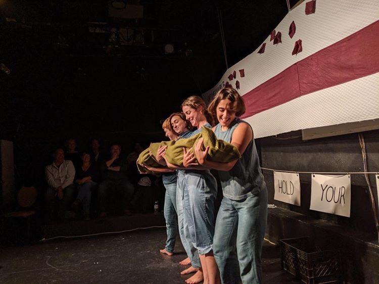 "Hard Feelings: A Show About Grudges" is a humorous exploration of what it means to make, hold, share, and shed a grudge. In the image, the applicants hold the "grudge," which is filled with ingredients offered up by the audience, such as spite, time, and tenacity. "Hard Feelings" is part of a larger body of work called "Say You're Sorry.