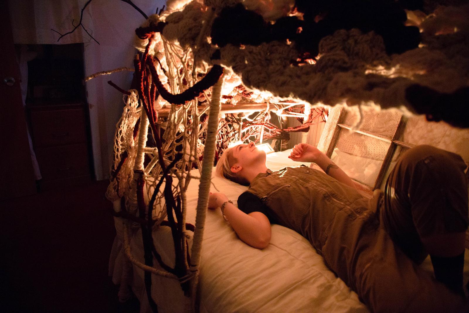 Household was a travelling show exhibited in both a house and gallery in Ann Arbor, Michigan. The work employed live art, video, audio, and sculpture to question structures of home and family. The applicants “played house,” creating works that revealed flaws in mythologies of home. Composition and installation audio engineering by Douglas Hertz, live french horn by Spencer Schaefer. The image provided shows Nest, an interactive installation that shields the participant. When entered, a lullaby composed and sung by the applicants plays.