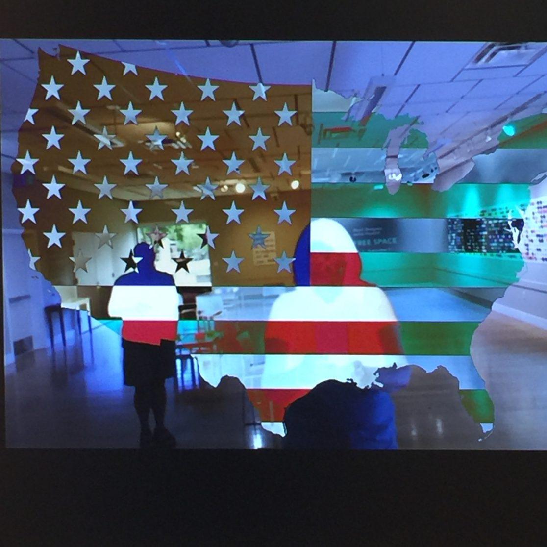 Video Still: interative video that overlays  person in front of camera with the American flag or obliterates them