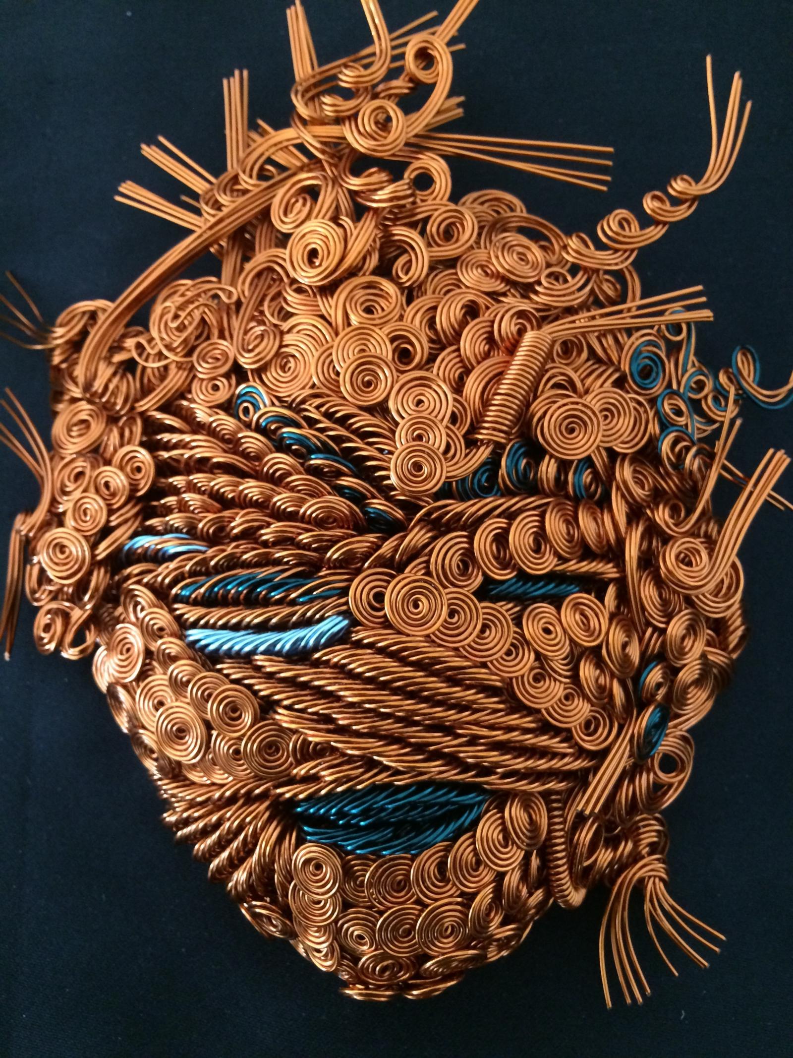 From 500-700 colored wire strands of various lengths and gauges are shaped and twisted into mask.
