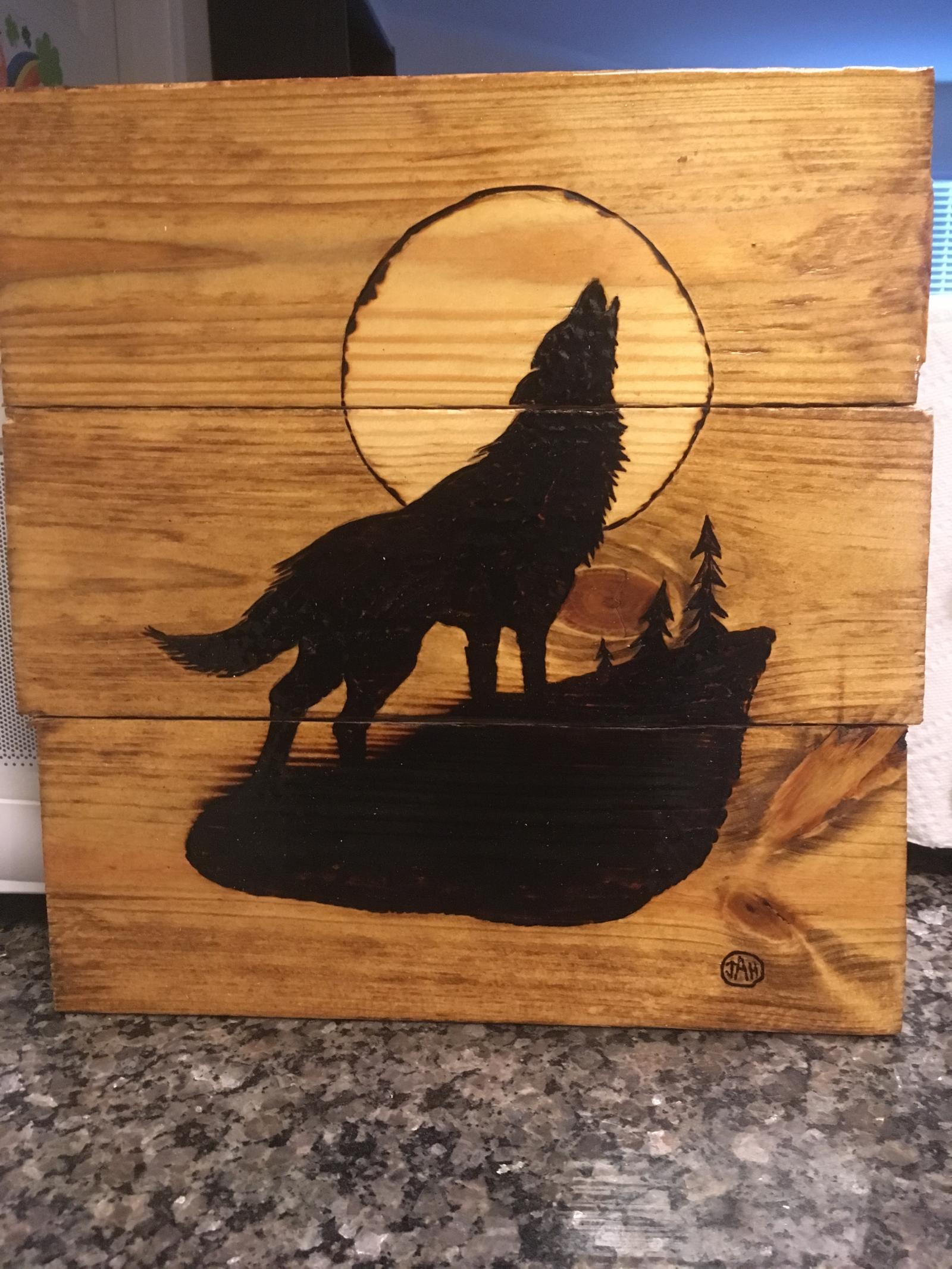 Wood burned wolf howling at moon on reclaimed pallet wood