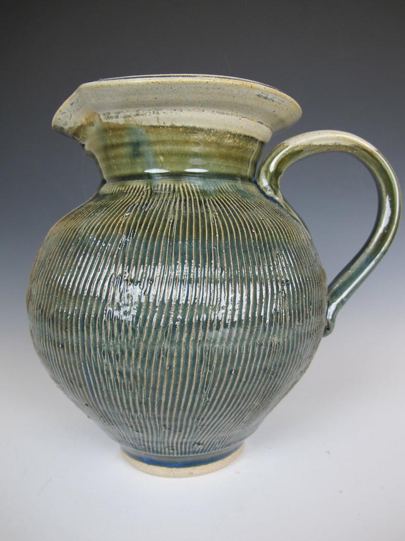 A highly textured stoneware pitcher fired in a reduction kiln.