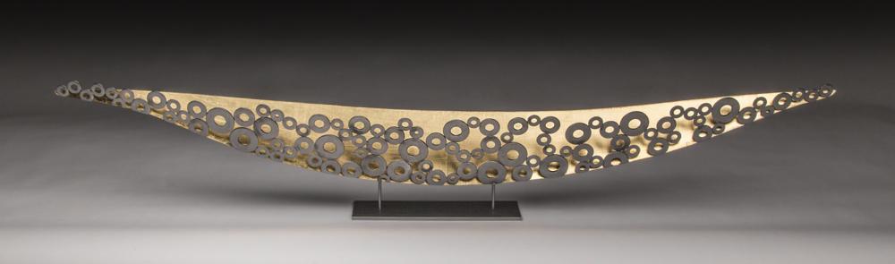 This boat sculpture combines the classic metallic silver and gold combination with both solid surface and texture from the pattern created by the washers.