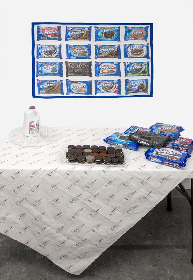 Oreo Quilt Installation - Quilt of 16 different Oreo Packages printed with archival pigment ink on cotton fabric presented with a table set with Oreo cookies and milk