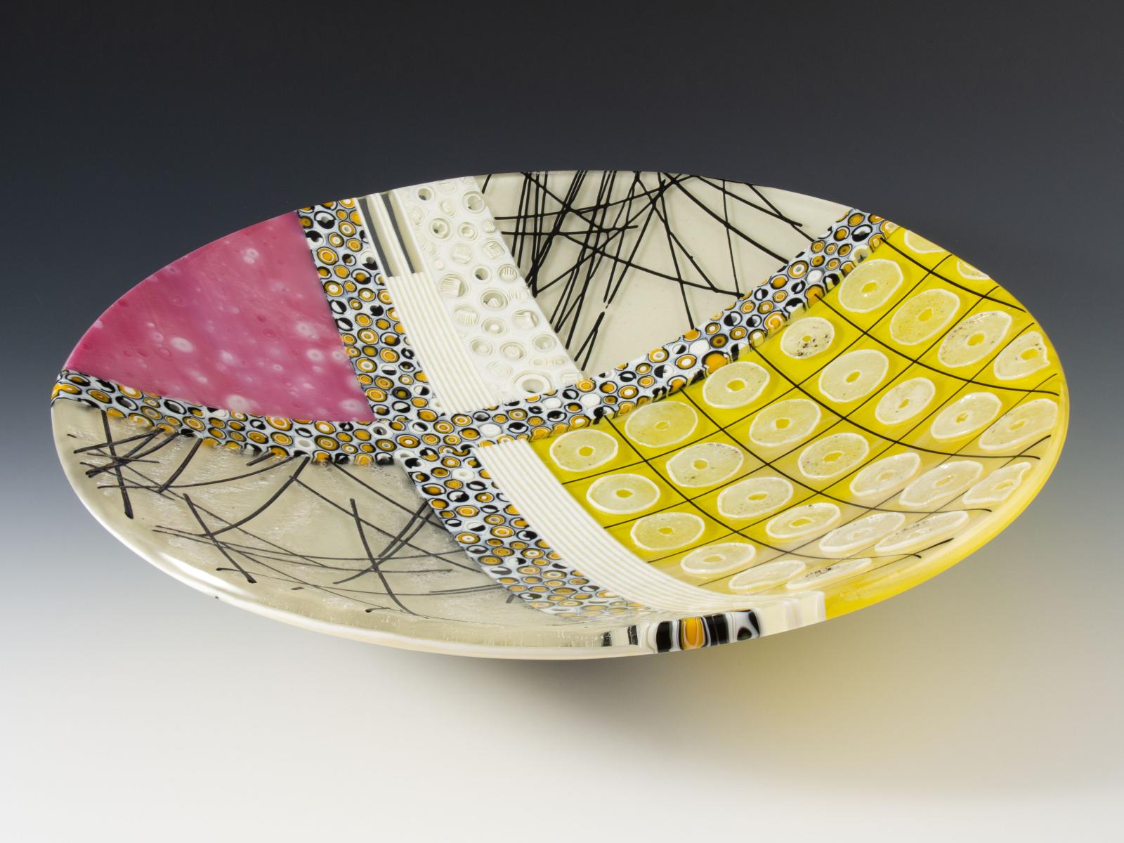 Bubbly pink, electric yellow, sparkling iridescence, complex patterned murrine, floating threads of glass, and raised rings of glass powder. You'll want to run your fingers over them every time you walk by.

The glass cylinders in this bowl are sections individually cut from hand-pulled glass cane which I create by heating glass to 1500 degrees and pulling it into rods while molten in a modern-day adaptation of the 16th century techniques of the Murano glassmakers.

Fused, coldworked and slumped.