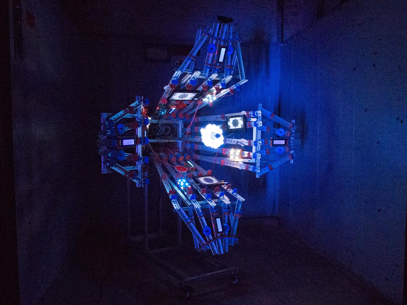 “Pollination” responds to faces and spoken words.
Its camera recognizes faces and splays them into rotating flower-like shapes; a central microphone listens for speech and shows its transcripts on a multitude of small screens.
In this work, I am analogizing the data that we spread when interacting in life to pollen: millions of invisible particles flowing in all directions with uncontrollable effects.
Nothing is uploaded from the artwork. “Pollination” uses “whisper.cpp,” a neural network (“AI”) speech transcription tool, to transcribe audio entirely within the device. Its facial recognition is powered by OpenCV. This is to say that many small computers are capable of listening to our speech and looking for our faces.
Neither technology is perfect; the same is true of other real-world applications. What happens if a real-time transcript of audio captured in a public place mishears your discussion of a broken ice maker as the name of a terrorist group? Or if a CCTV’s live facial recognition security product misidentifies you?