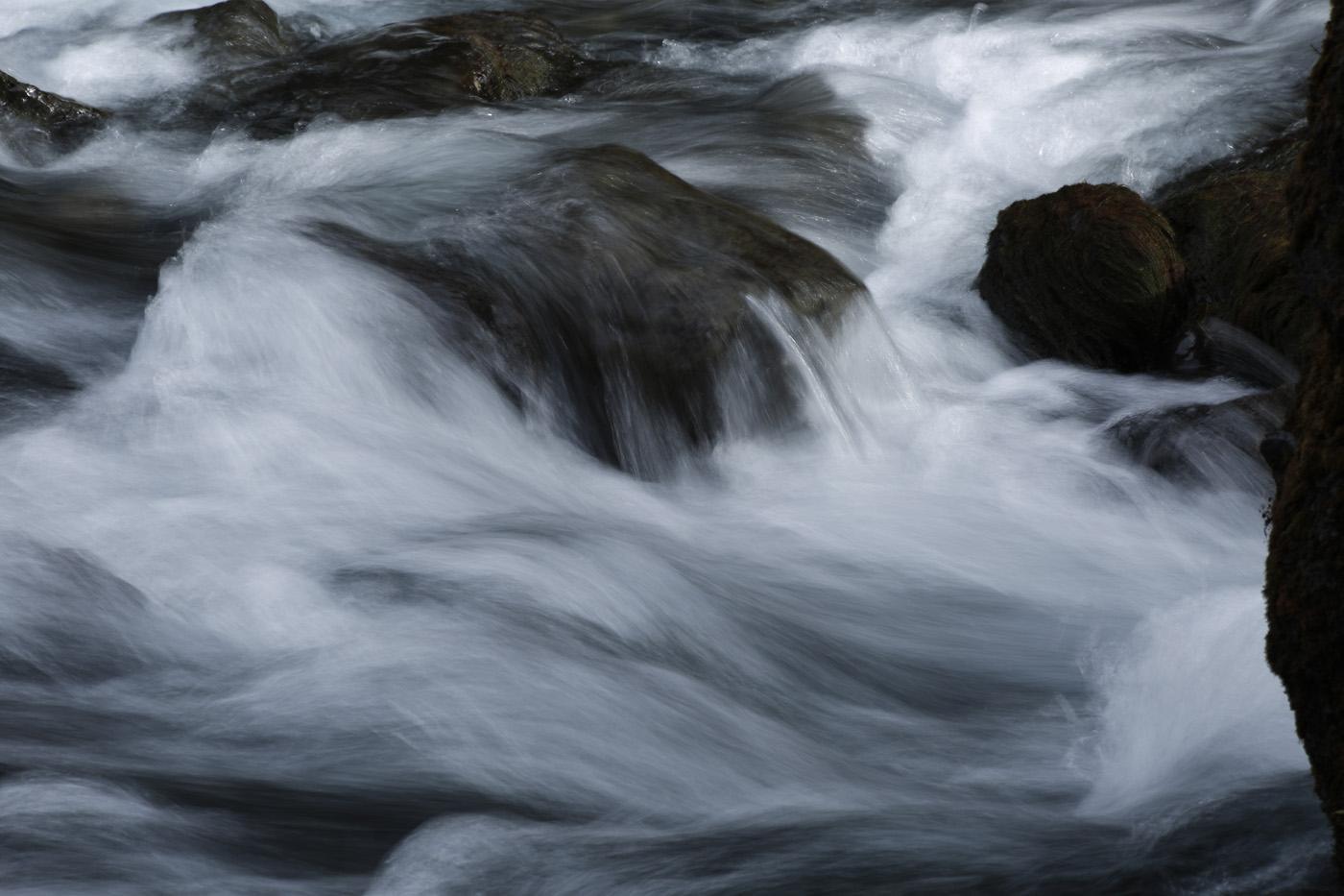 Long exposure of the rocks at the base of an Icelandic waterfall taken in winter.