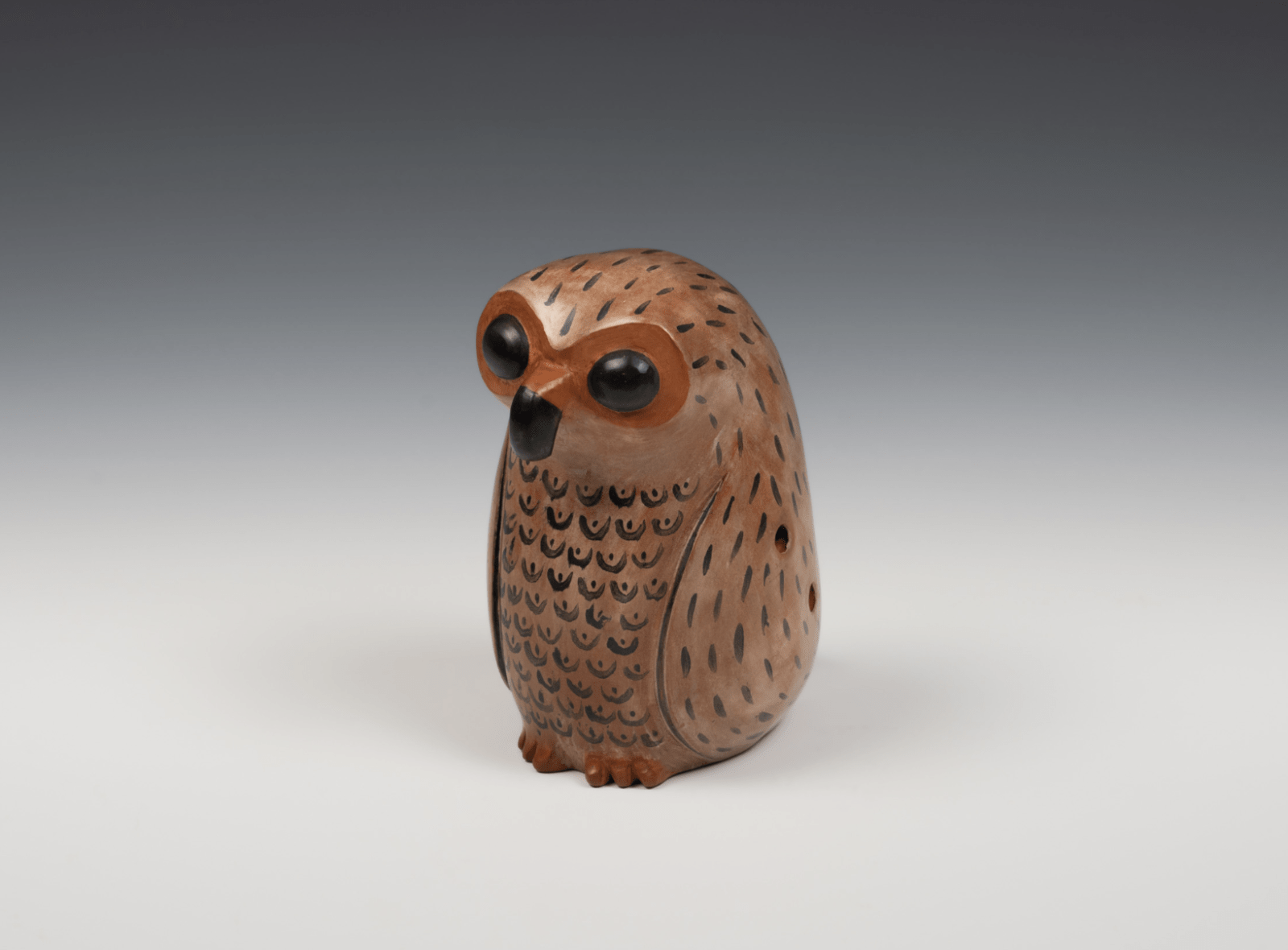 Globular or vessel style flute in the shape of an owl with painted iconography.
