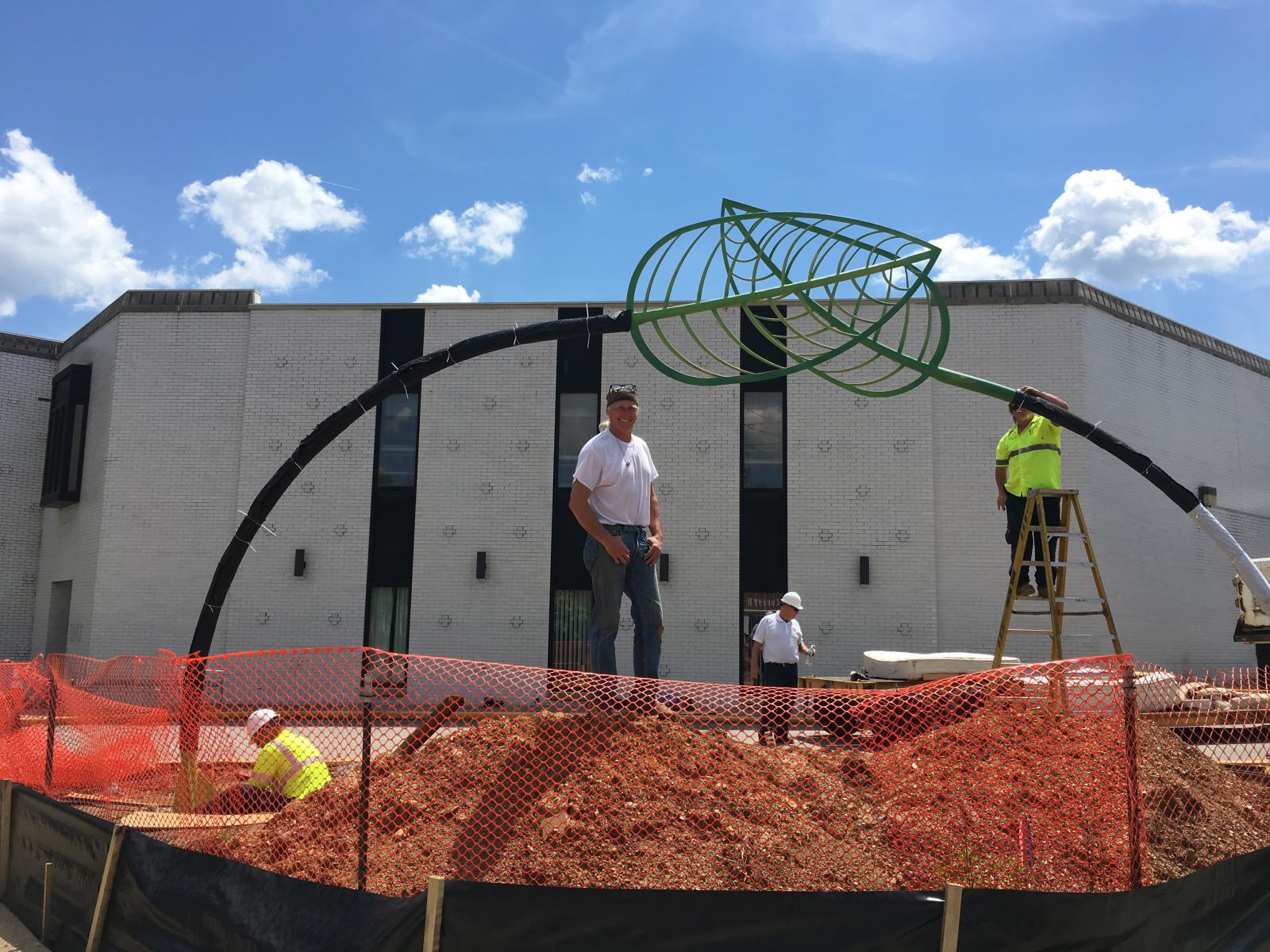 Two 17' tall painted steel sprouts reach toward each other, at the corner of Bond and Main Streets, Westminster MD.