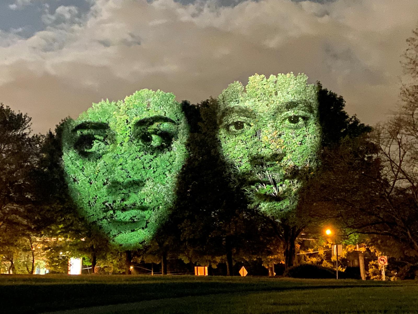 Monuments: Creative Forces, a campus-wide outdoor art installation at Strathmore by Australian artist Craig Walsh, October 2020.
The exhibition featured moving, dimensional video portraits of artists whose work and artistic endeavors are changing the shape of our community in profound ways. Expansive video portraits of these creative heroes, chosen by a diverse panel of community and arts leaders, were projected on to towering trees, transforming them into animated sculptural monuments.
Photo by Jim Saah.
