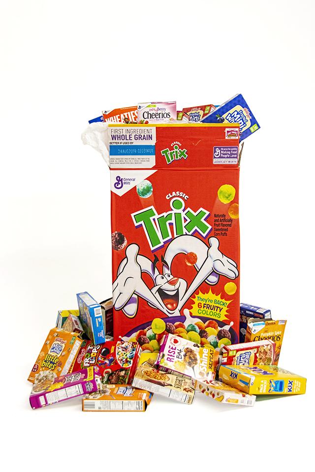 Sculpture of Trix cereal box surrounded by cereal boxes and styrofoam Trix cereal - Trix cereal box measures 25 in. x 51 in. x 9 in. - installation with cereal boxes is approximately 36 in. x 51 in. x 24 in.