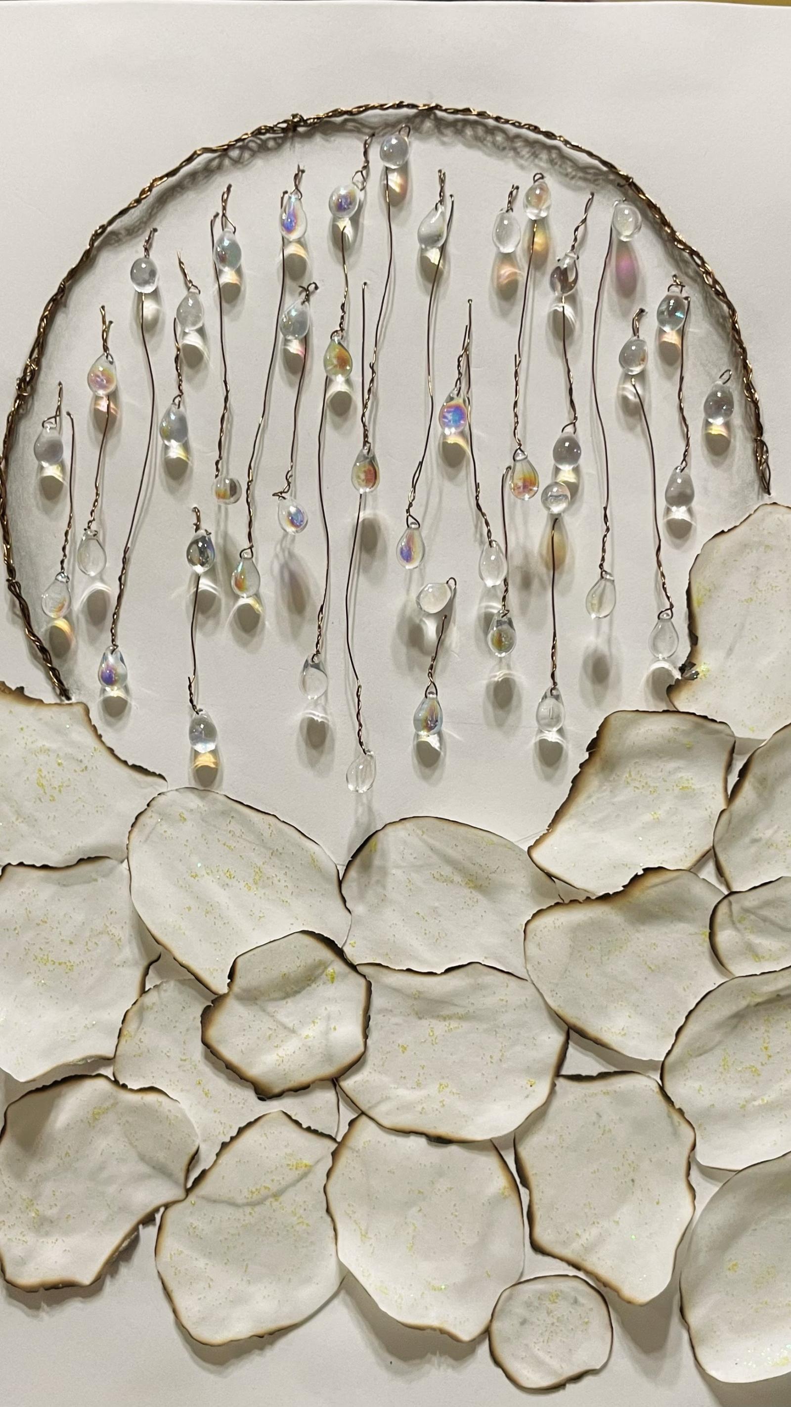 This piece recently appeared on the cover of Passager, edited by Christine Lincoln. Making art for this cover was a timely and healing opportunity to create something beautiful out of a moment of total upheaval in my life. Sometimes we have to let our hands and fingers move us through these tsunamis. Circles from chats with the editor became vellum paper orbs singed around the edges by a candle's flame, cooled by streaks of glitter glue signifying the indestructible presence of spirit. Braided copper wire became the border of a larger circle filled with glass teardrops hung from single strands of wire. There's a lot happening in this piece that I did not consciously intend and that baffles me, still. But of this I am certain: We're all a little burnt around the edges from life's traumas and pain, watered by our collective tears of radiant light.