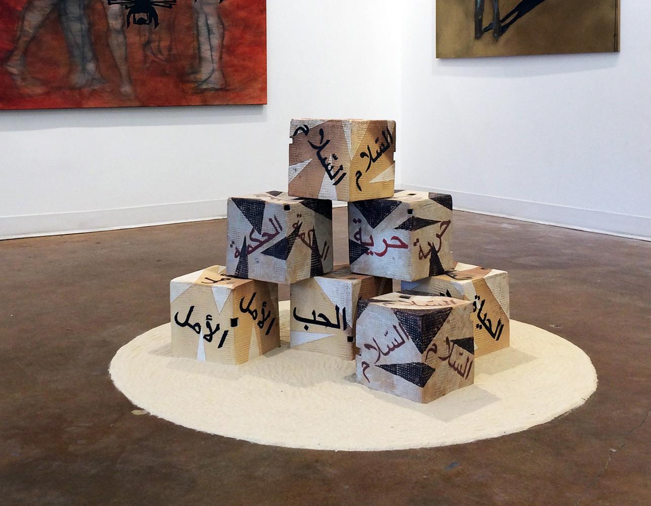 I teach at an area college with international students, many from the Muslim-majority countries that are part of the current US travel ban. When Spring semester began in January 2017 there was palpable anxiety in my classroom, and the idea for this installation took shape at that time. 

The abstract, cubic form was deliberately chosen for its symmetry and association with truth and the “corner stone” or foundation. The clay used in the making of the sculpture is entirely recycled from the material used by ceramic students at the college. Arabic calligraphy (common to all nations,) is used to inscribe the words, which include: Love, Wisdom, Hope, Peace, Freedom and Life – all universal concepts that are being increasingly threatened, today.
