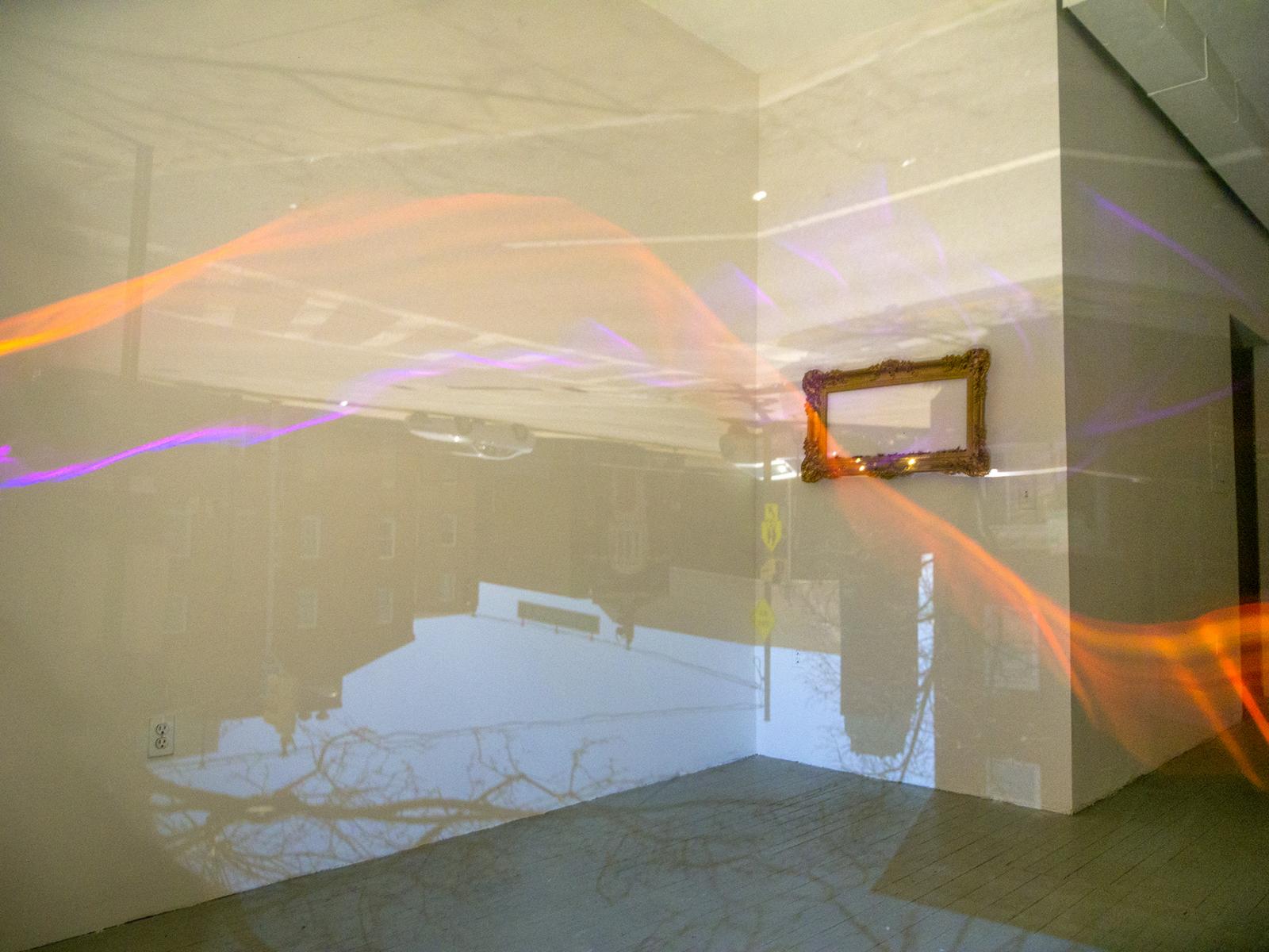 This photograph is a 6 minute exposure inside a room size camera obscura. While the outside scene is projected into the space, a brother and sister discussed life after retirement while pacing the floor with colored lights attached to their bodies.